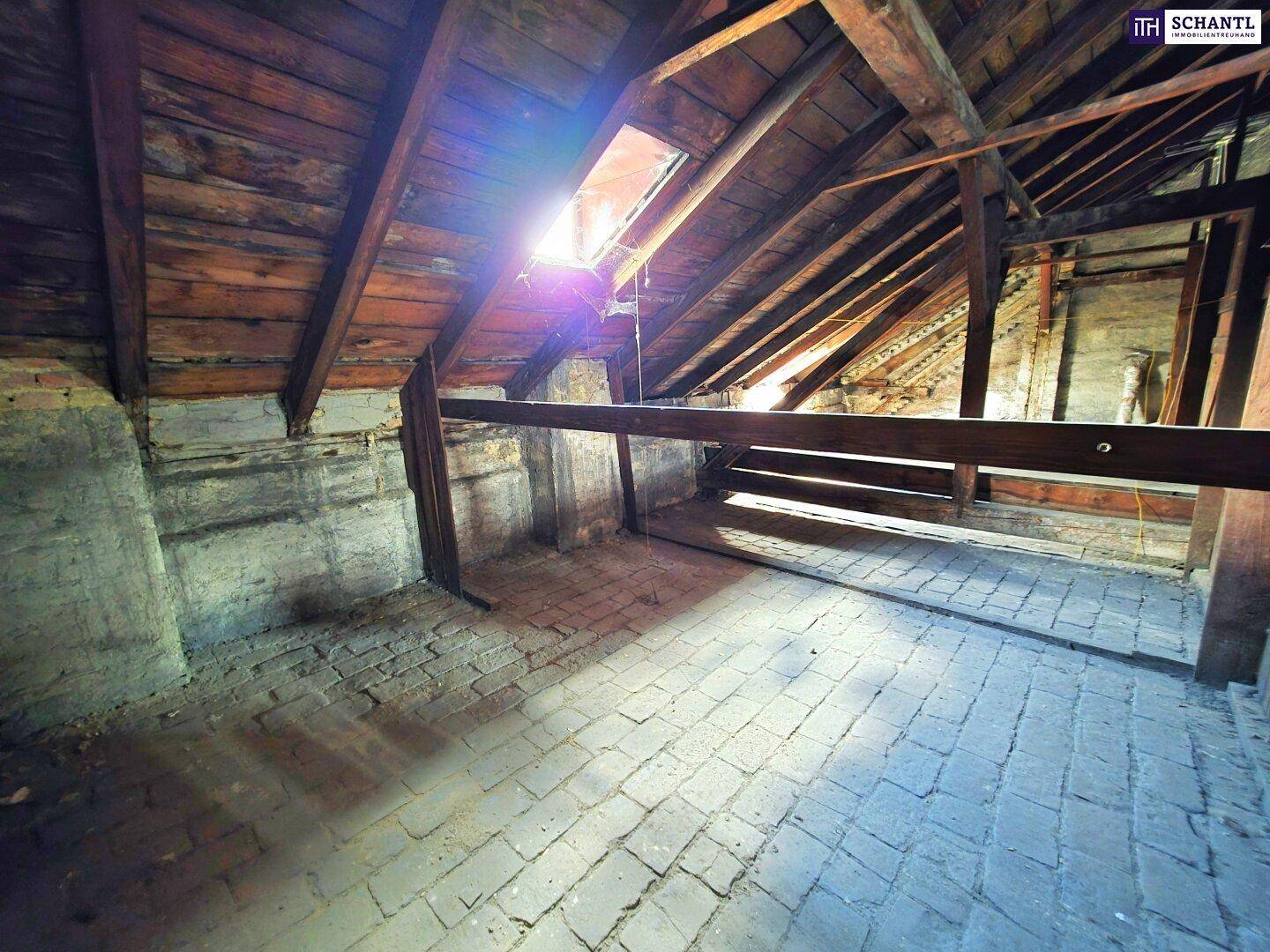 Heller Dachboden mit sichtbaren Holzbalken, Ziegelboden und einem Dachfenster für natürliches Licht.