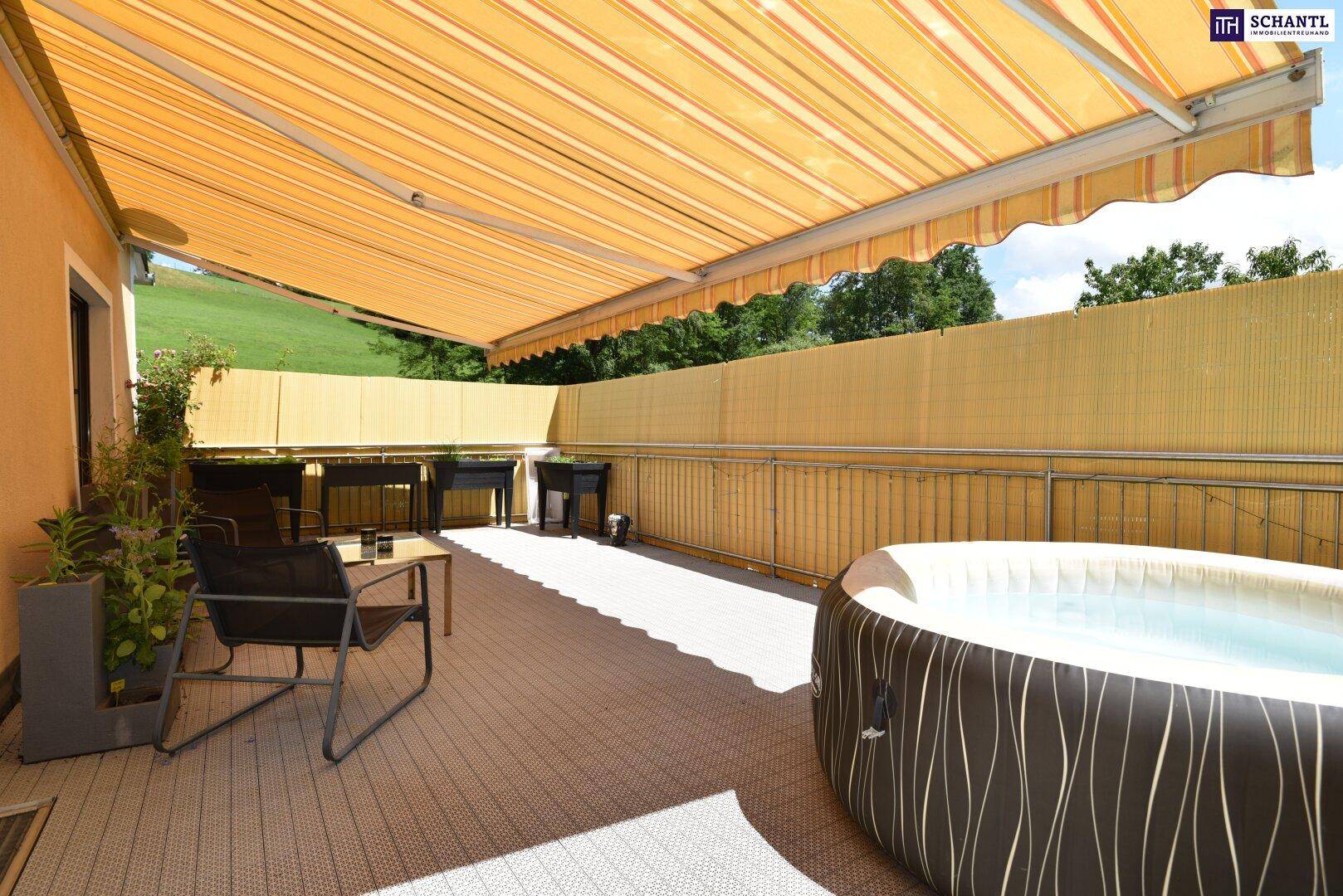 Große überdachte Terrasse mit Whirlpool, Gartenmöbeln und Markise für entspannte Stunden.