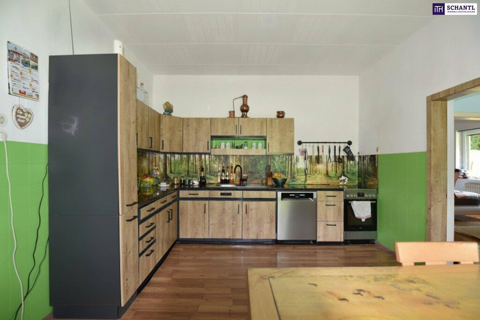 Funktionale Küche mit Holzfronten, integrierten Geräten und Essbereich.