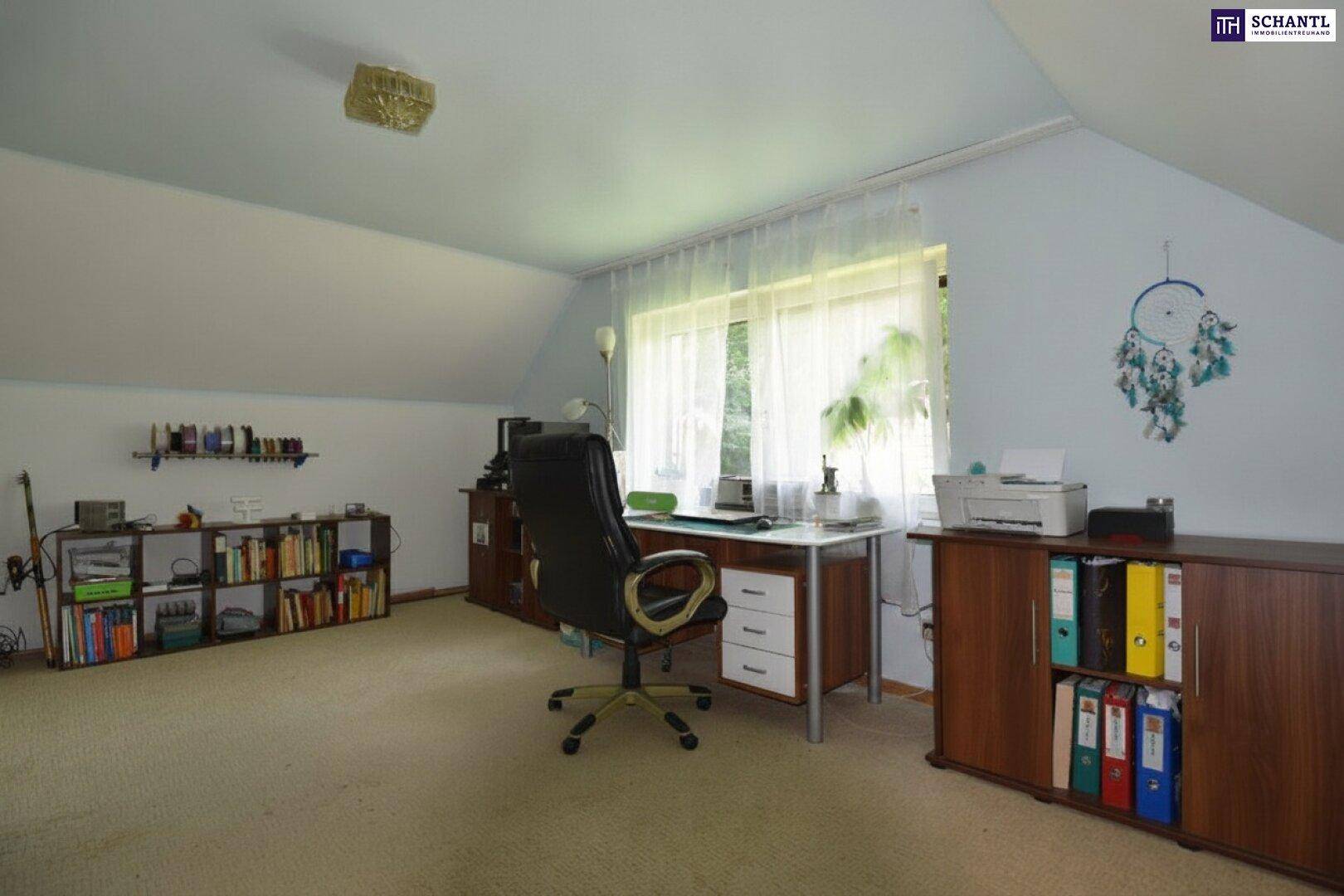 Helles Dachzimmer als Büro genutzt, mit Schreibtisch, Bürostuhl und Bücherregalen unter schrägen Decken.