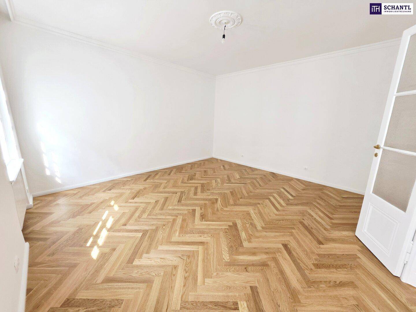 Helles Zimmer mit Fischgrätparkett, hohen Decken und Stuckelementen, bereit zur individuellen Gestaltung.