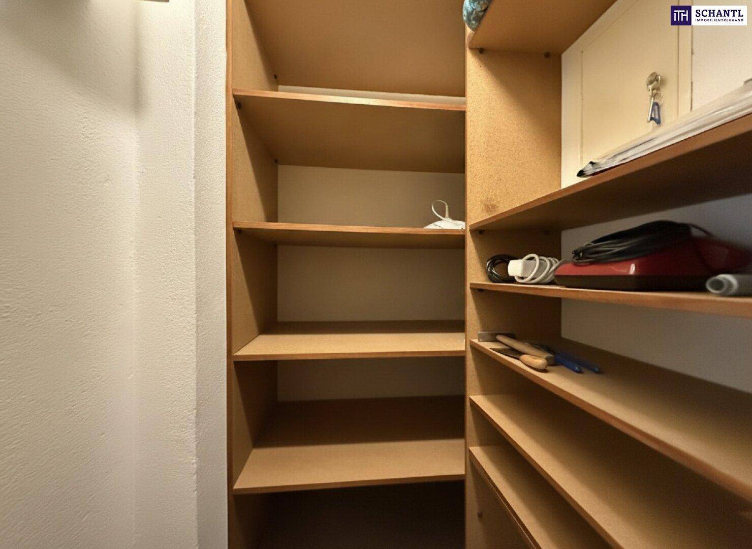 Praktischer Abstellraum mit mehreren Holzregalen für zusätzlichen Stauraum.