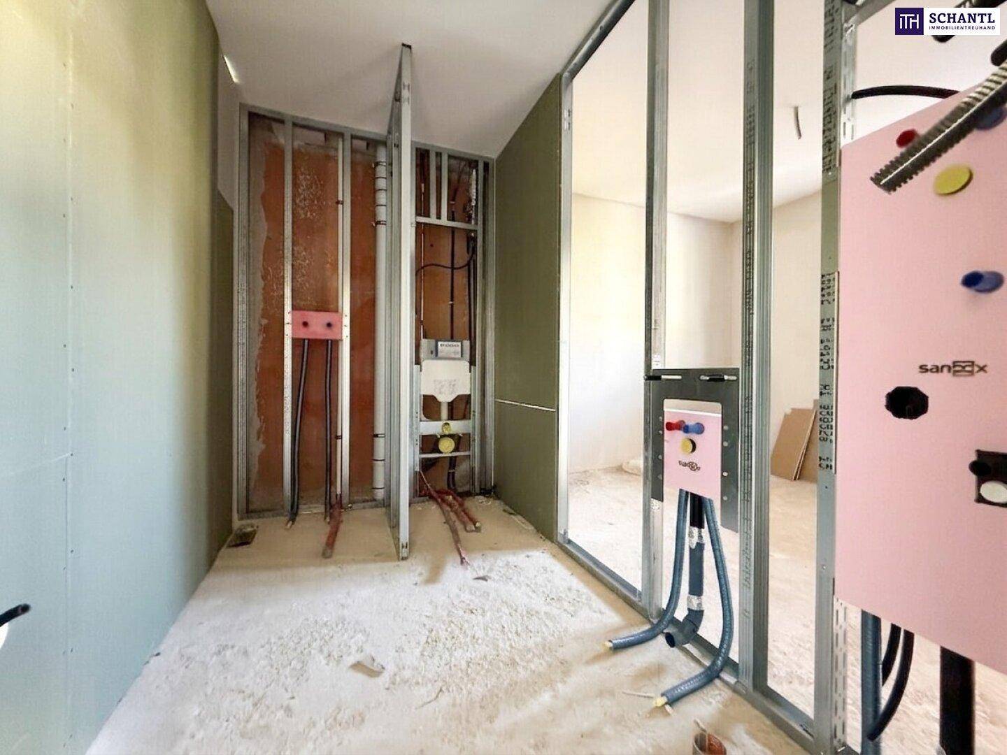 Rohbau eines Badezimmers mit sichtbaren Sanitärinstallationen und Wandständerwerk.