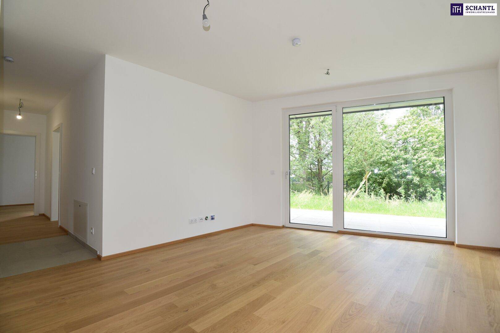 Helles, leeres Wohnzimmer mit Holzboden und großen Schiebetüren, die viel Tageslicht hereinlassen.