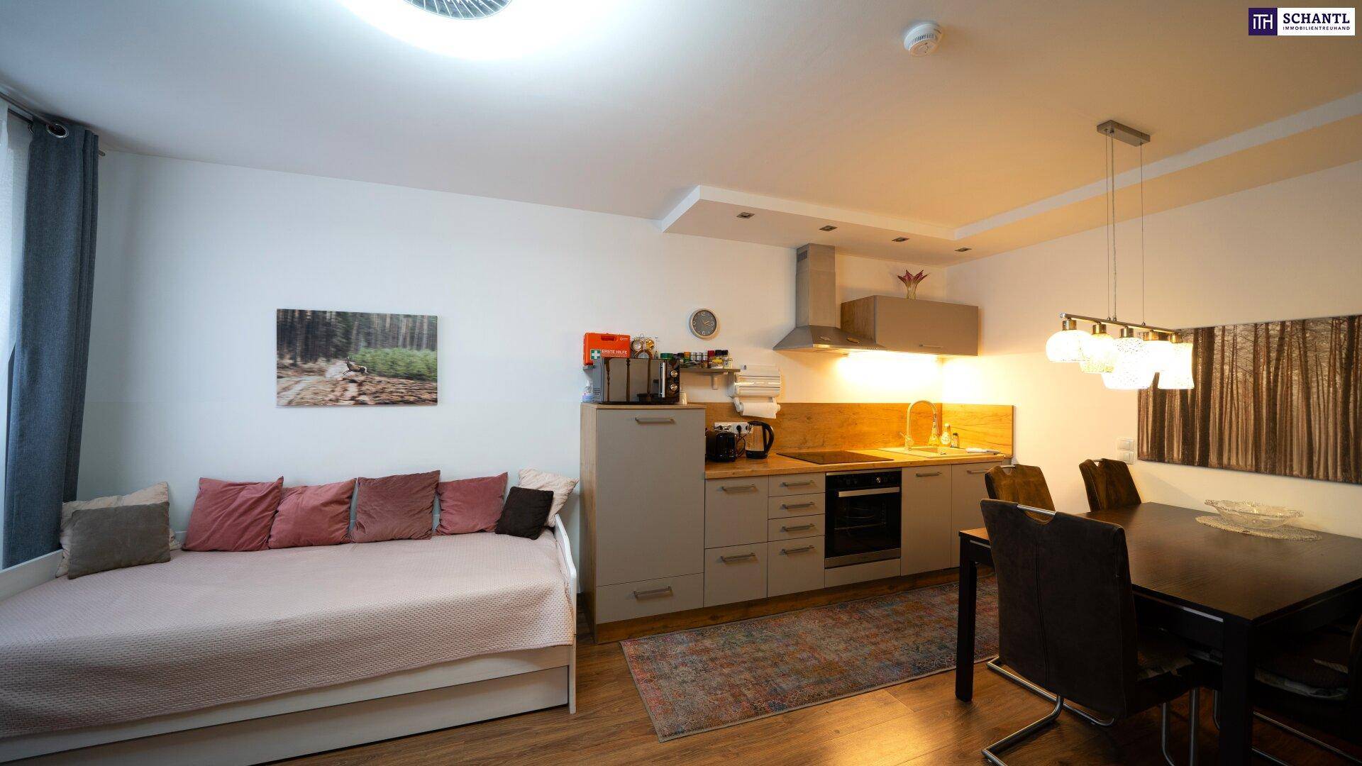 Moderne Küche mit Essbereich und angrenzendem Wohnbereich mit Tagesbett.