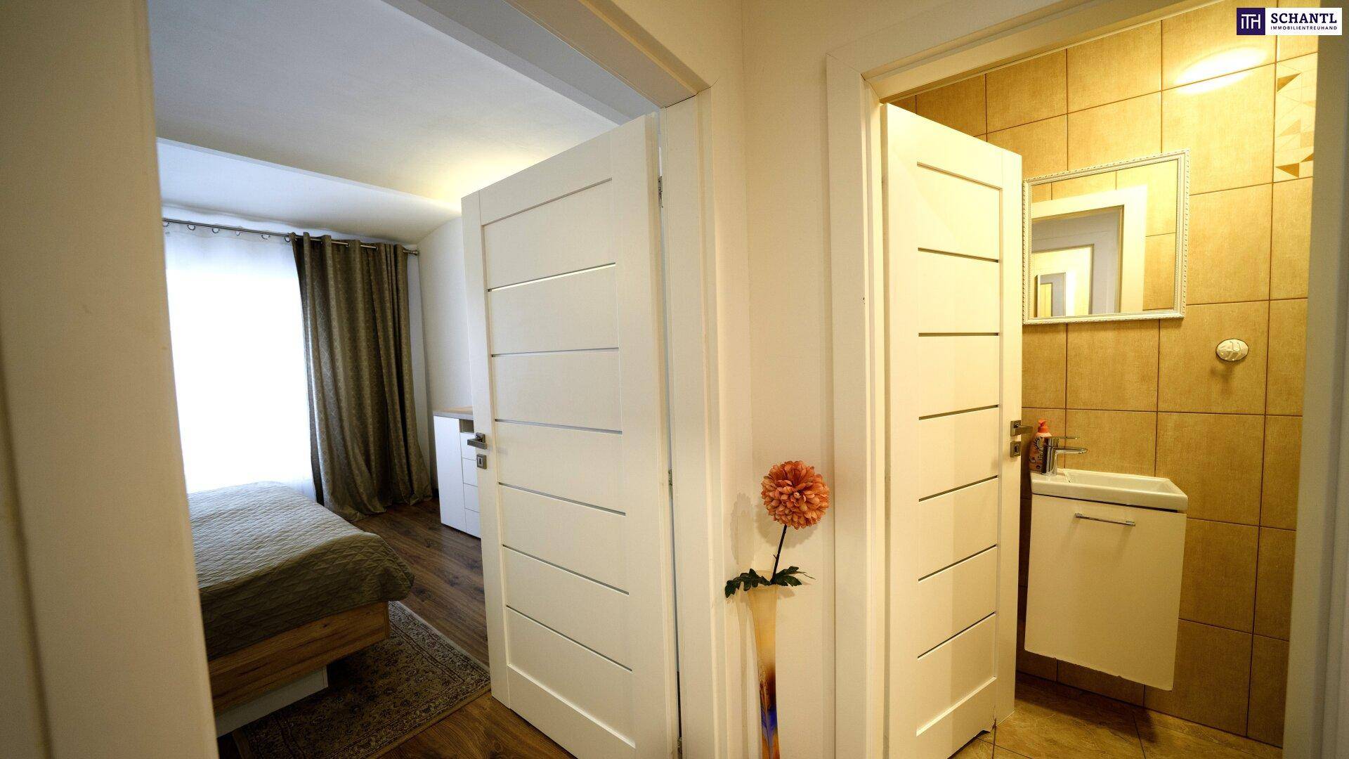 Heller Flur mit Zugang zu einem Schlafzimmer und einem Badezimmer.