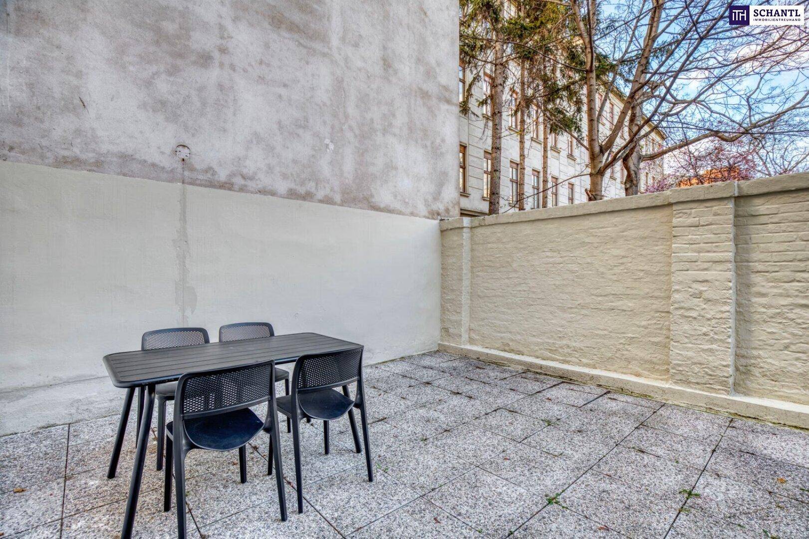 Gepflasterter Außenbereich mit Tisch und Stühlen, ideal für entspannte Stunden im Freien.