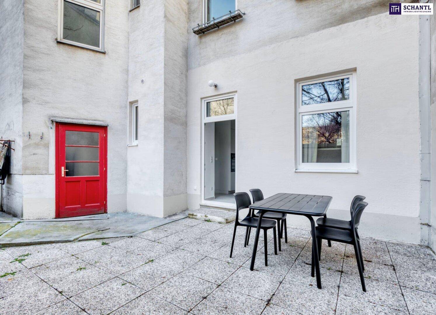 Heller, gepflasterter Patio mit Zugang zum Gebäude und Sitzgelegenheiten im Freien.