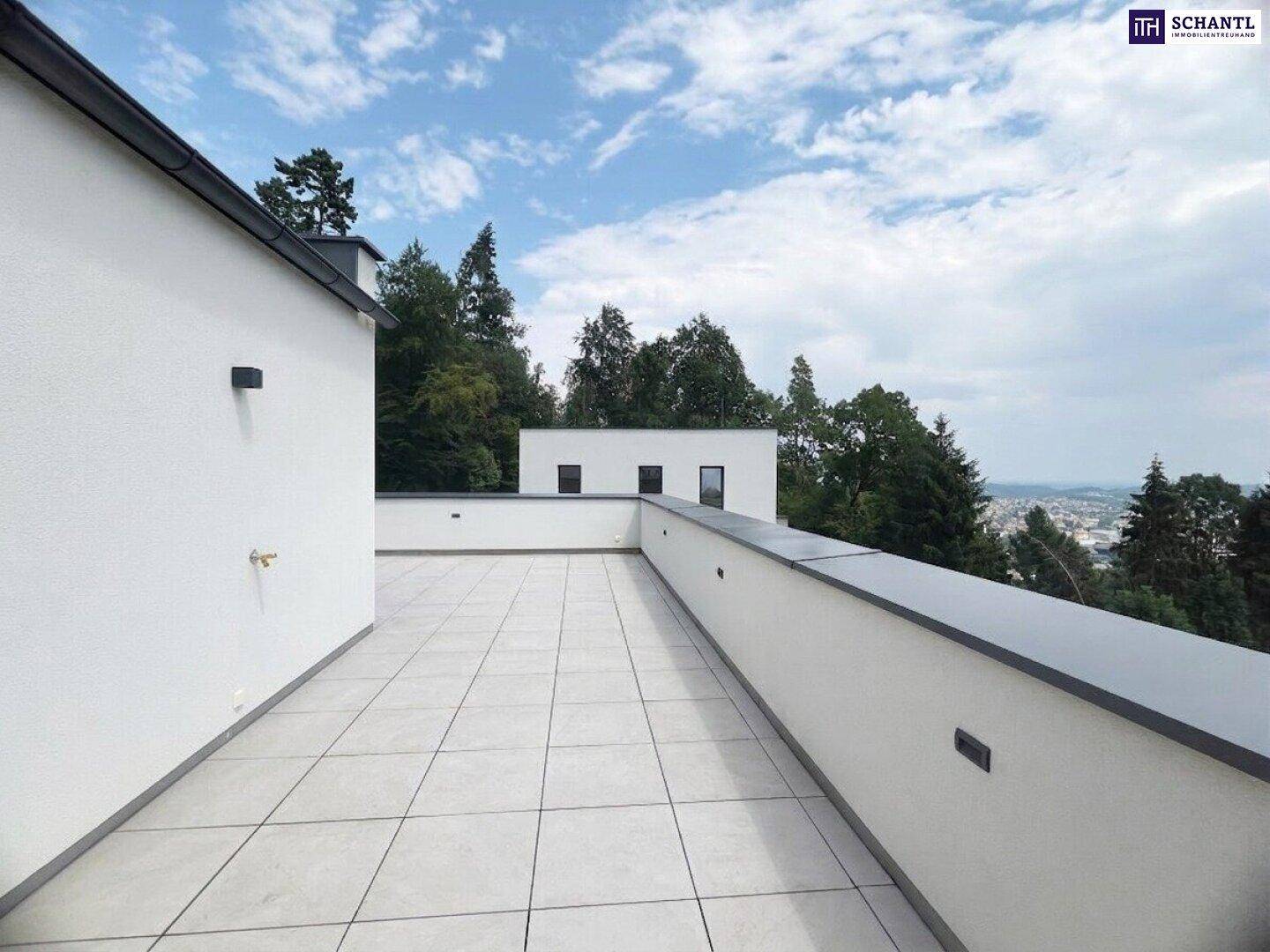 Geräumige, geflieste Dachterrasse mit moderner Architektur und weitem Blick ins Grüne.