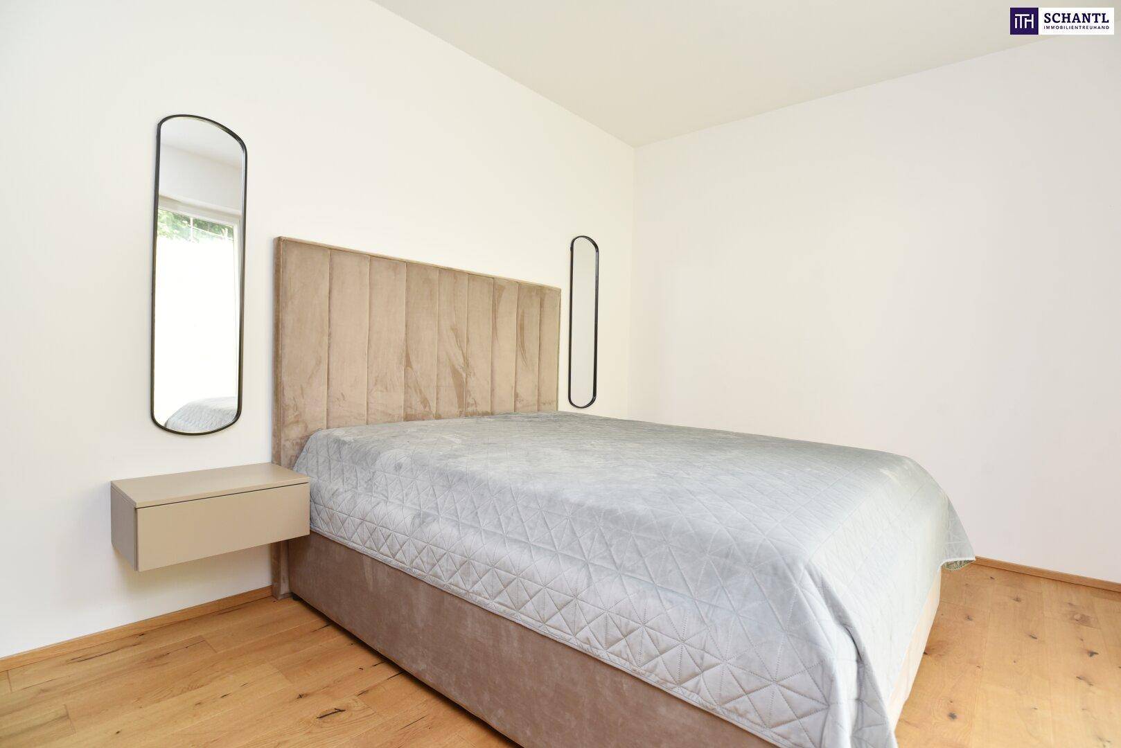 Schlafzimmer mit Doppelbett, Holzboden und schwebendem Nachttisch.