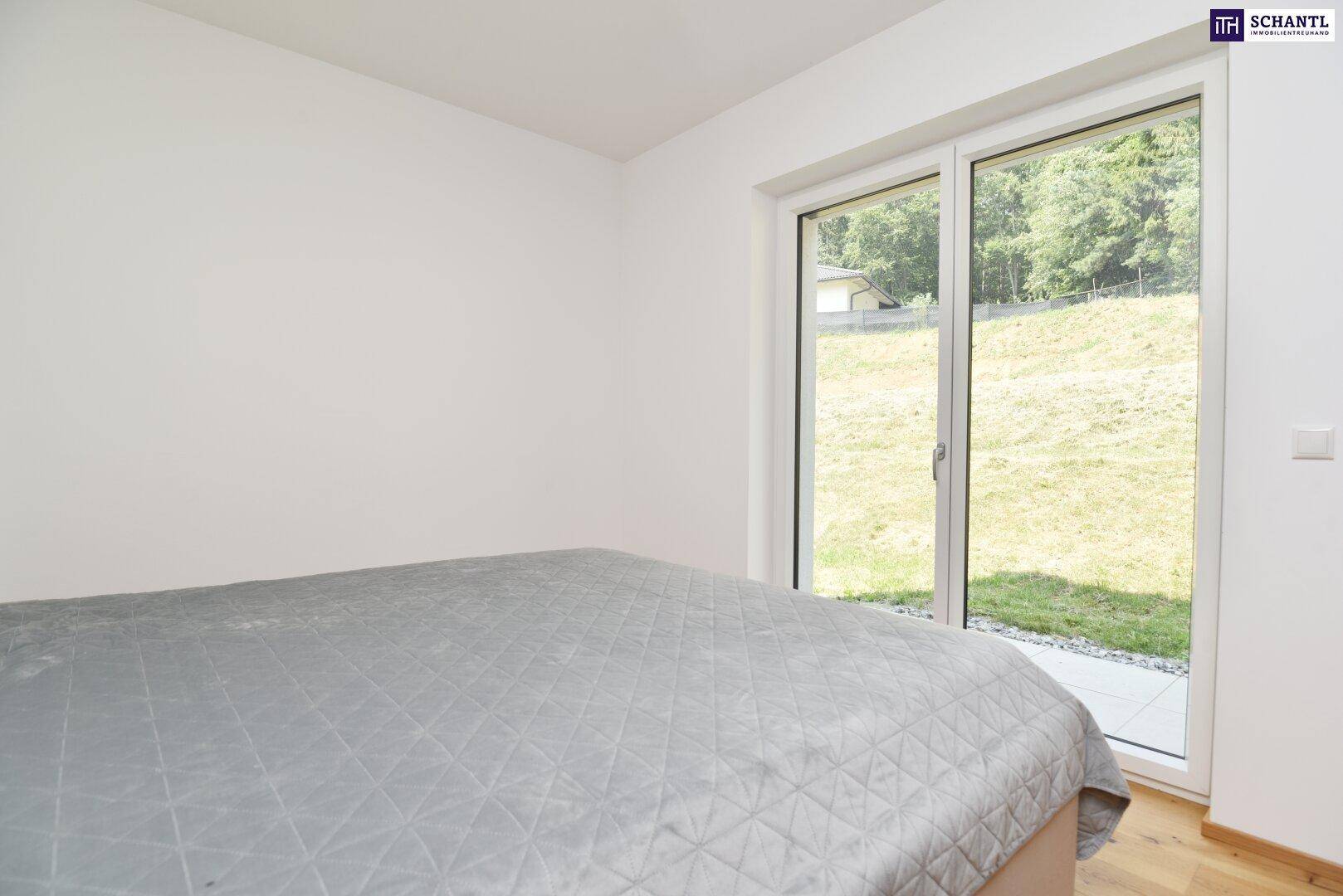 Helles Schlafzimmer mit Zugang zur Terrasse und Blick ins Grüne.