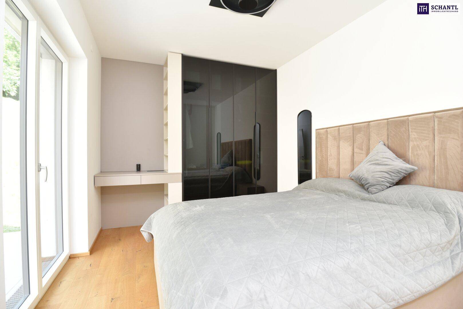 Schlafzimmer mit integriertem Schreibtisch, Einbauschrank und Holzboden.
