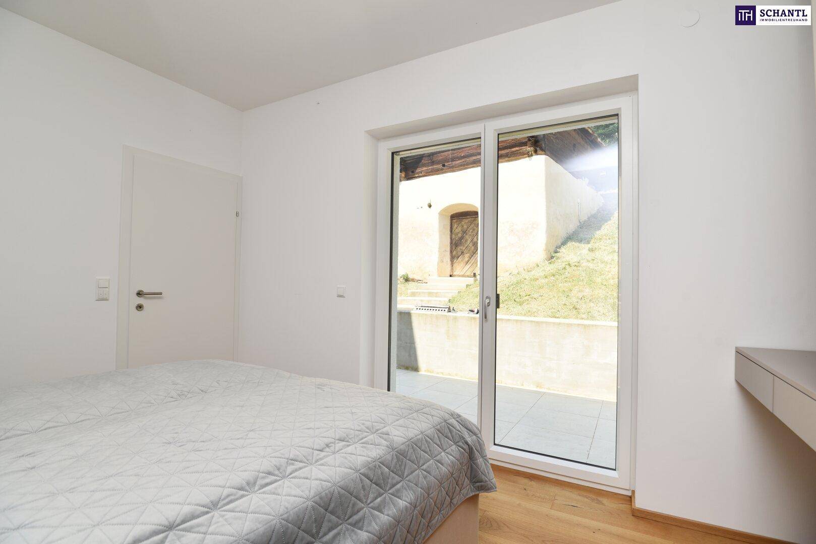 Schlafzimmer mit großer Schiebetür, die den Blick auf den Außenbereich freigibt.