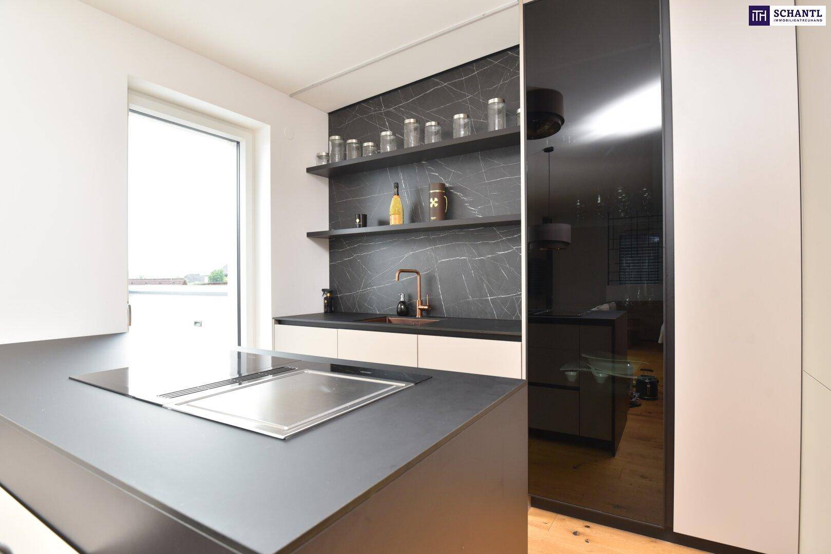 Moderne Küchenzeile mit Induktionskochfeld, dunkler Arbeitsplatte und kupferfarbenem Spülbecken.