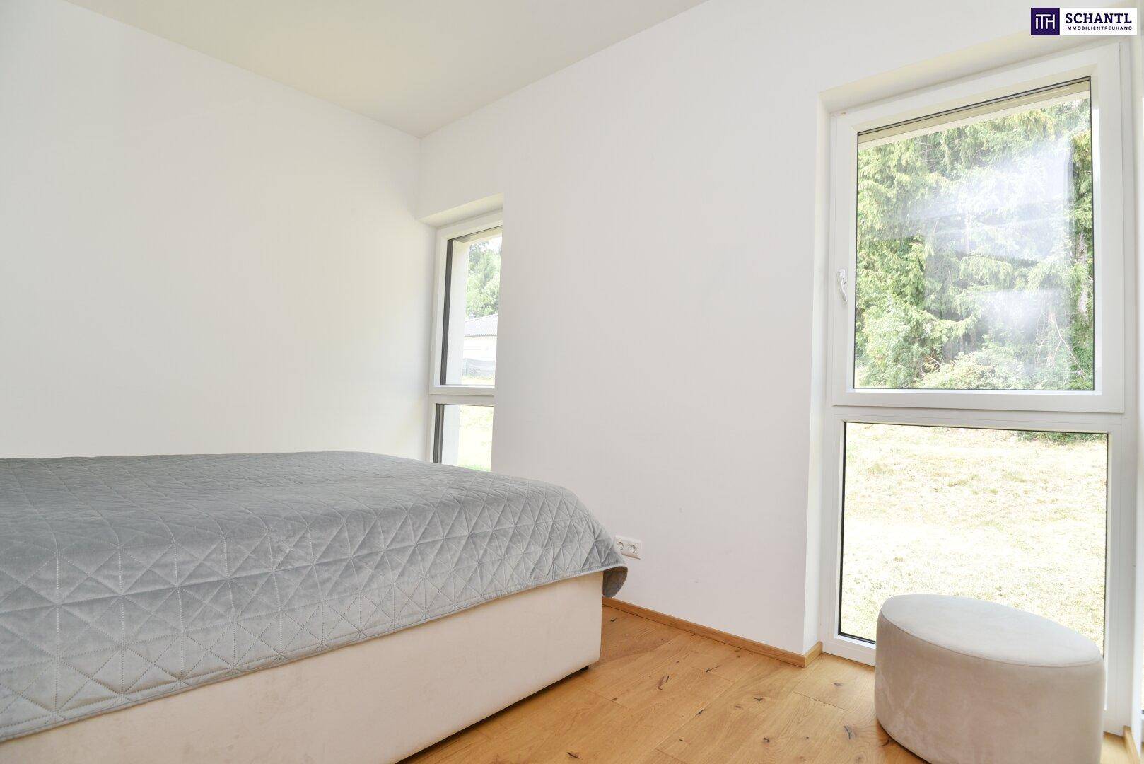 Helles Schlafzimmer mit zwei Fenstern, die einen schönen Blick ins Grüne bieten.