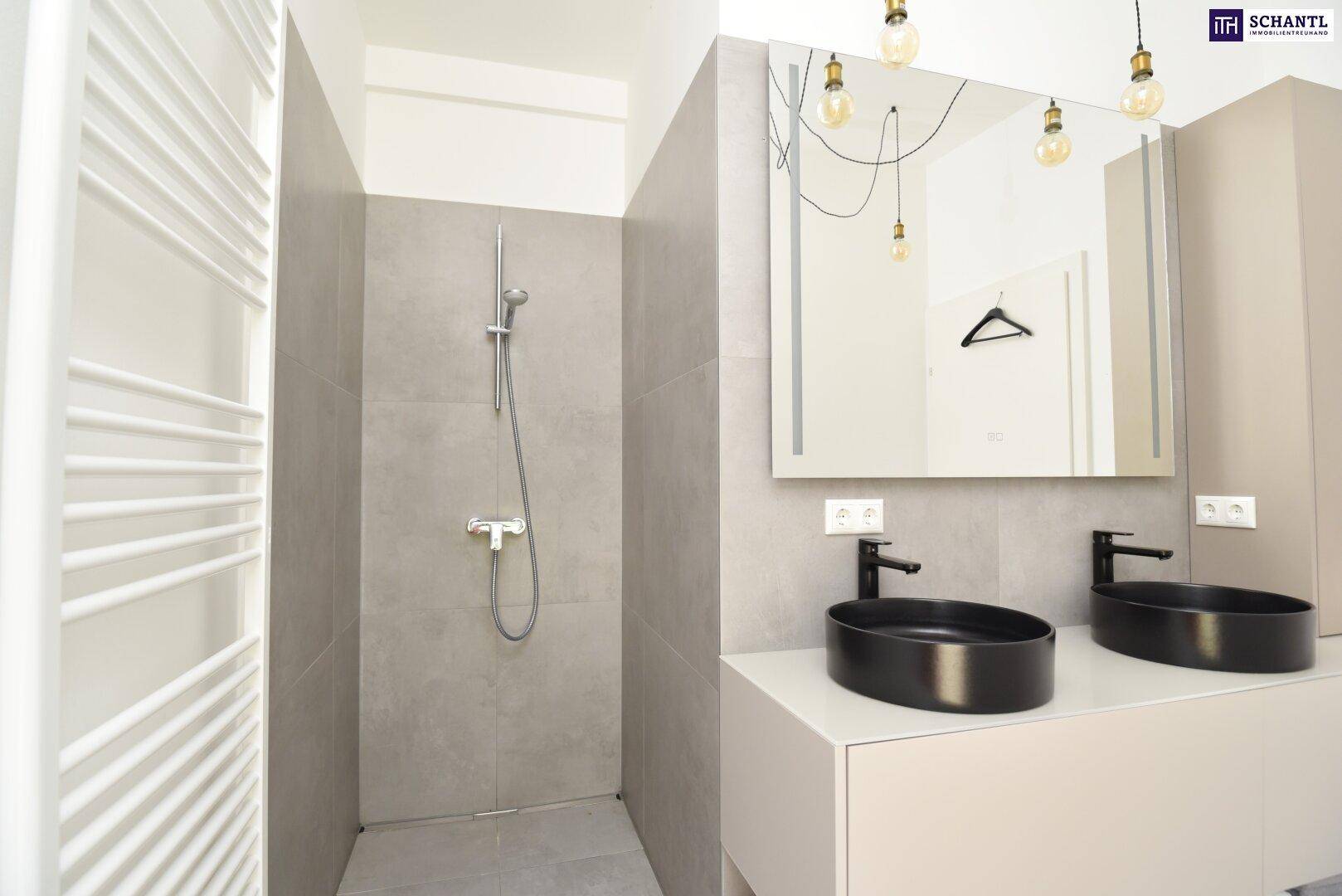 Badezimmer mit begehbarer Dusche, Doppelwaschbecken und beheiztem Handtuchhalter in modernem Design.