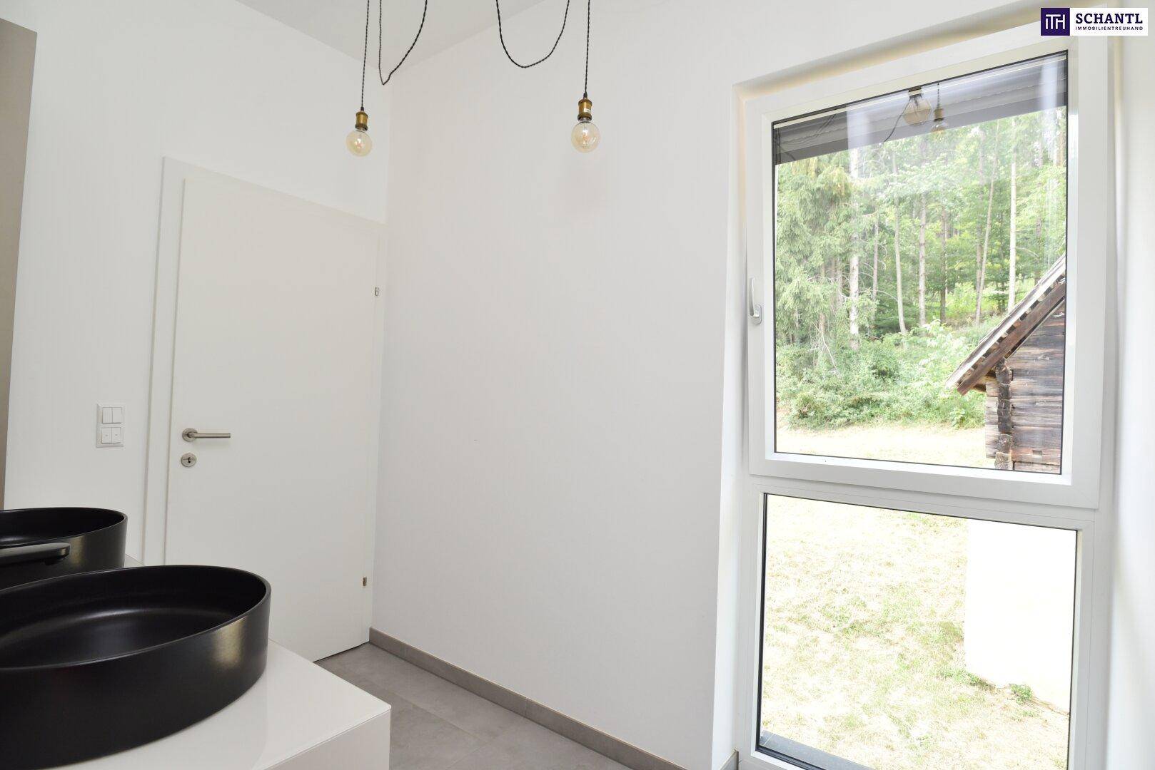 Helles Badezimmer mit Fenster, Doppelwaschbecken und Blick ins Grüne.