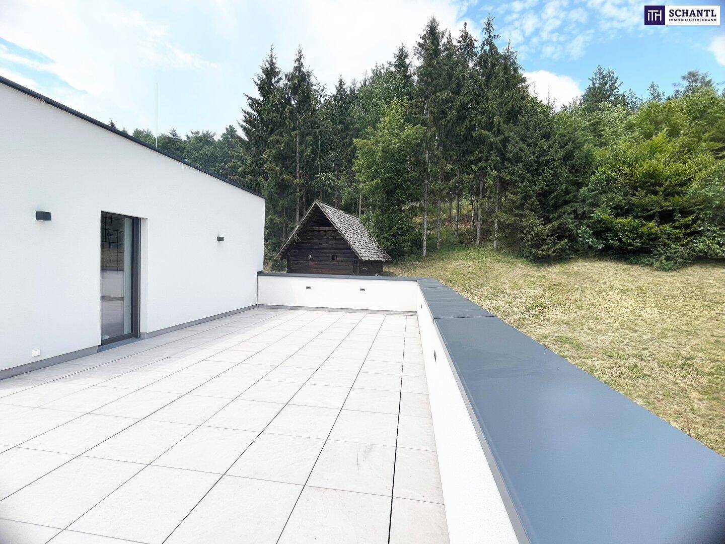 Großzügige Terrasse mit modernen Fliesen und direktem Zugang zum grünen Außenbereich.