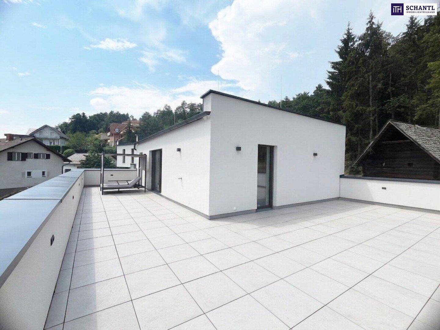 Große, moderne Dachterrasse mit hellen Fliesen und Blick auf die Umgebung.