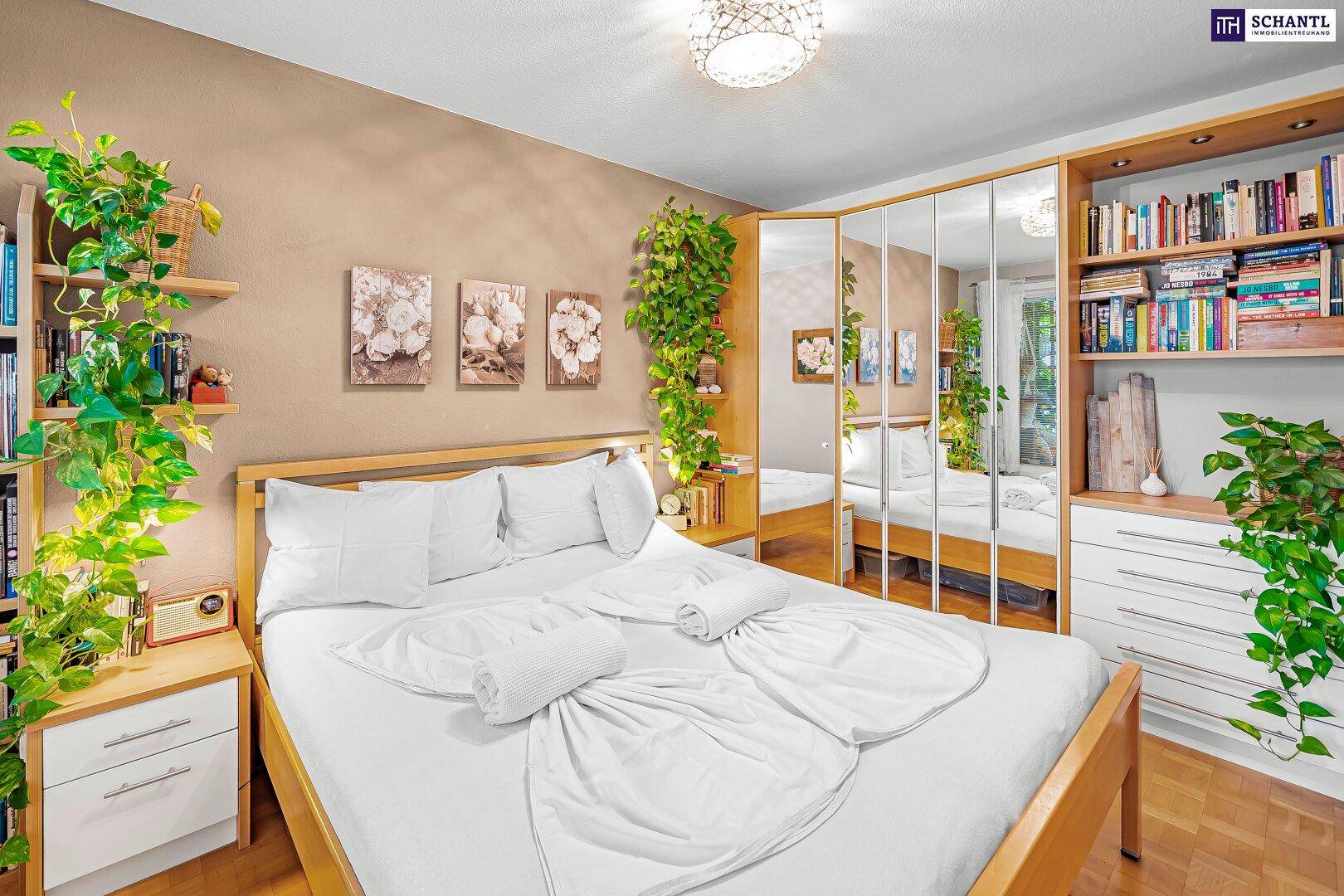 Gemütliches Schlafzimmer mit Doppelbett, Spiegelschrank und Bücherregalen, hell und wohnlich.