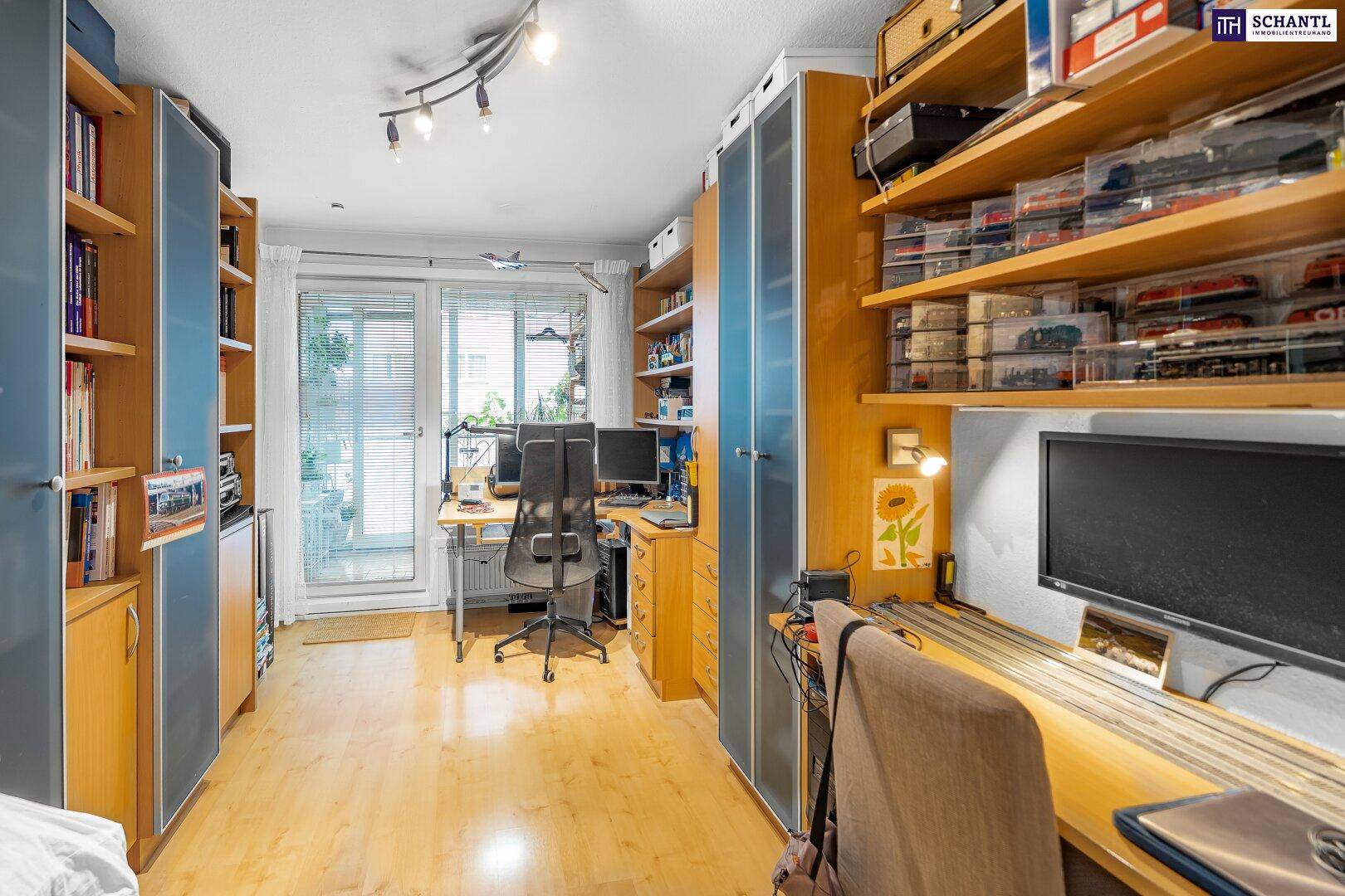 Helles Arbeitszimmer mit Schreibtischen, Regalen und Zugang zu einem Außenbereich.