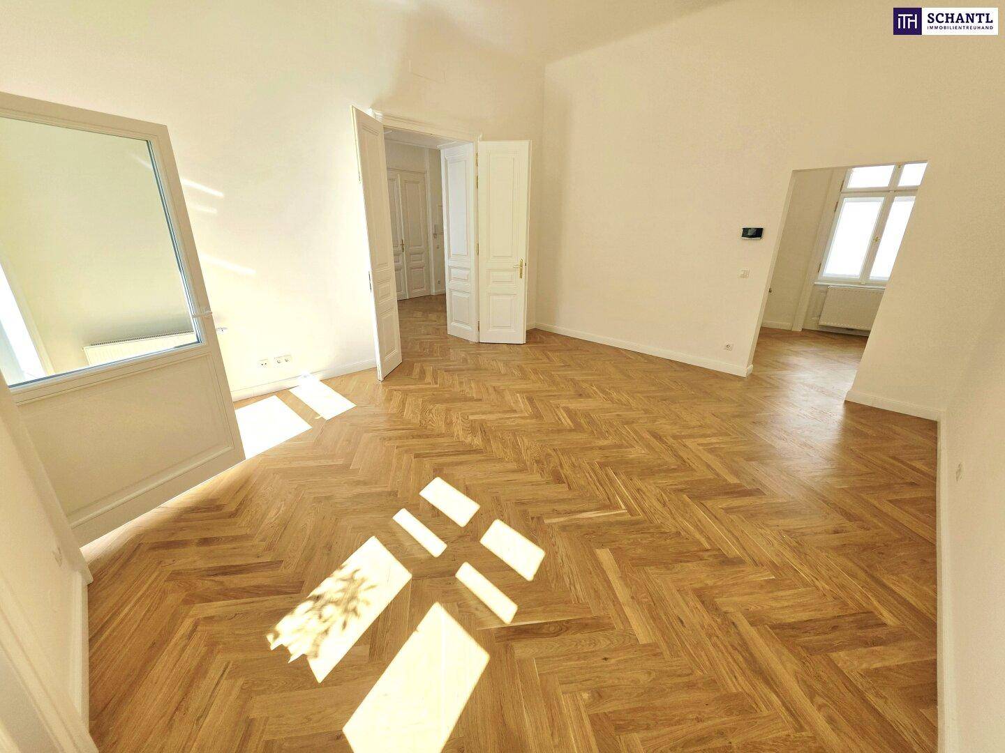 Geräumiges Zimmer mit klassischem Fischgrätparkett und hohen Türen, bereit zur individuellen Gestaltung.