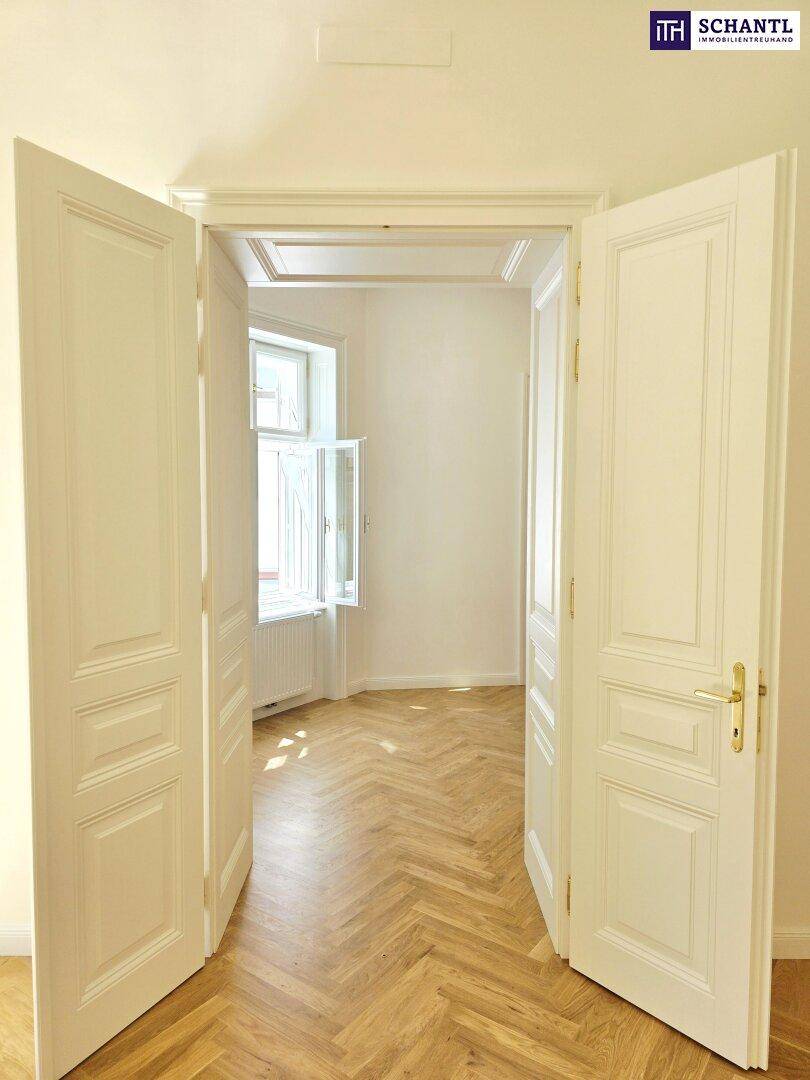 Elegante Doppeltüren mit Kassettendesign, die den Übergang zwischen den hellen Räumen betonen.