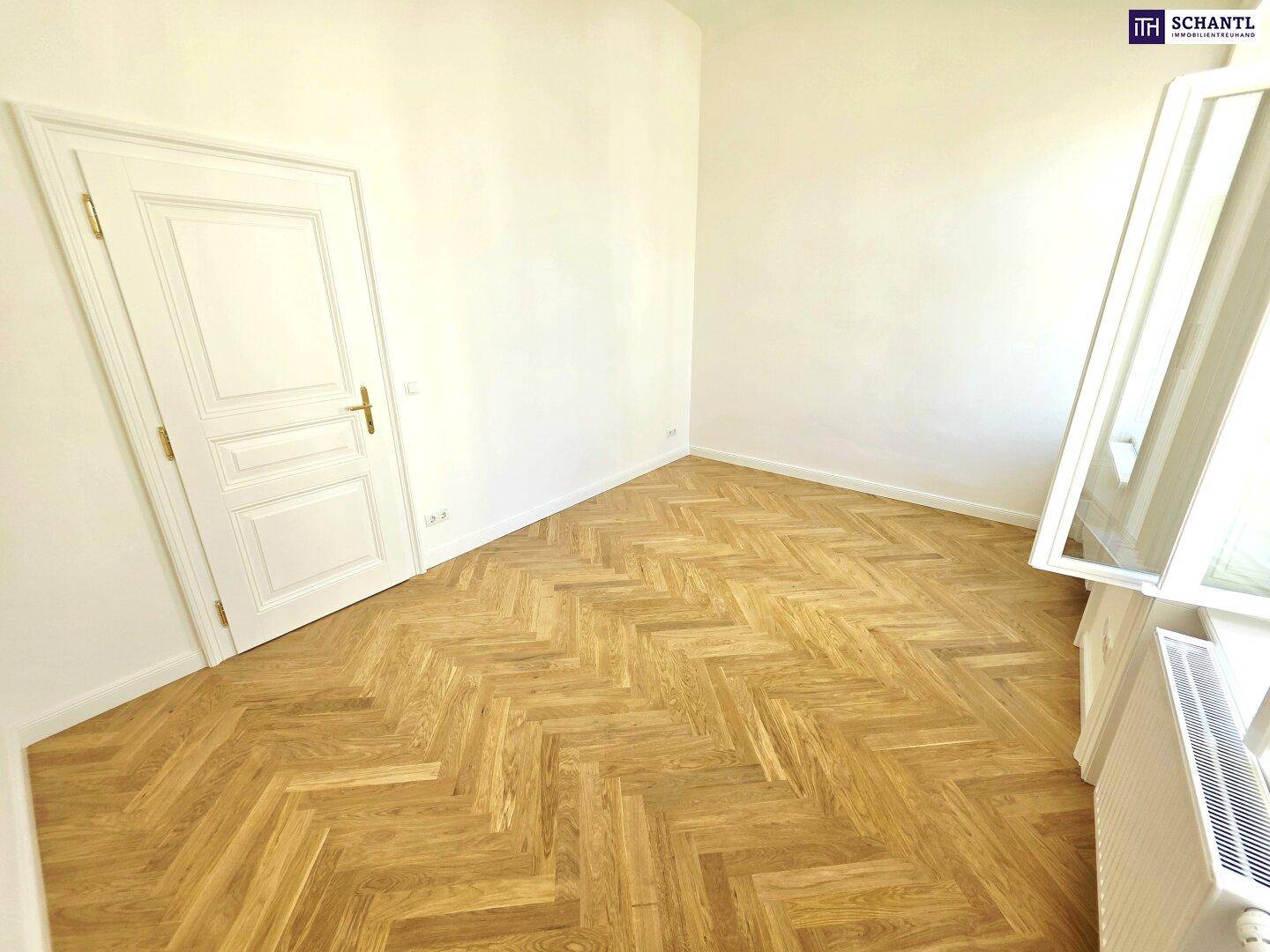 Heller Raum mit Fischgrätparkett und hohen Decken, der eine angenehme Wohnatmosphäre schafft.
