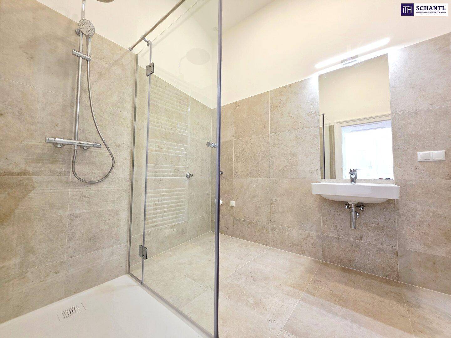 Modernes Badezimmer mit großer begehbarer Dusche, Einzelwaschbecken und hellen Fliesen.