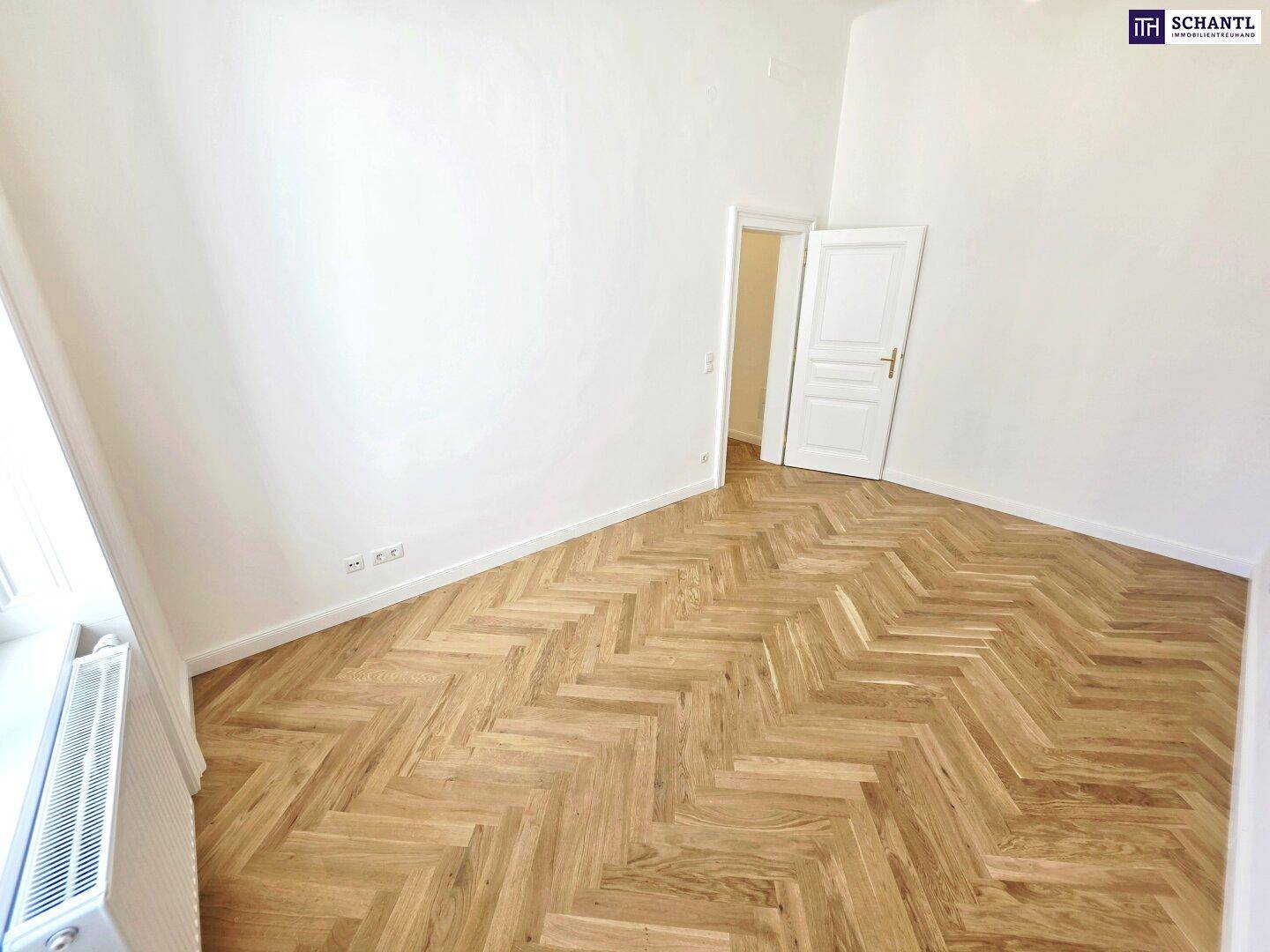 Heller Raum mit Fischgrätparkett und hohen Decken, der eine angenehme Wohnatmosphäre schafft.