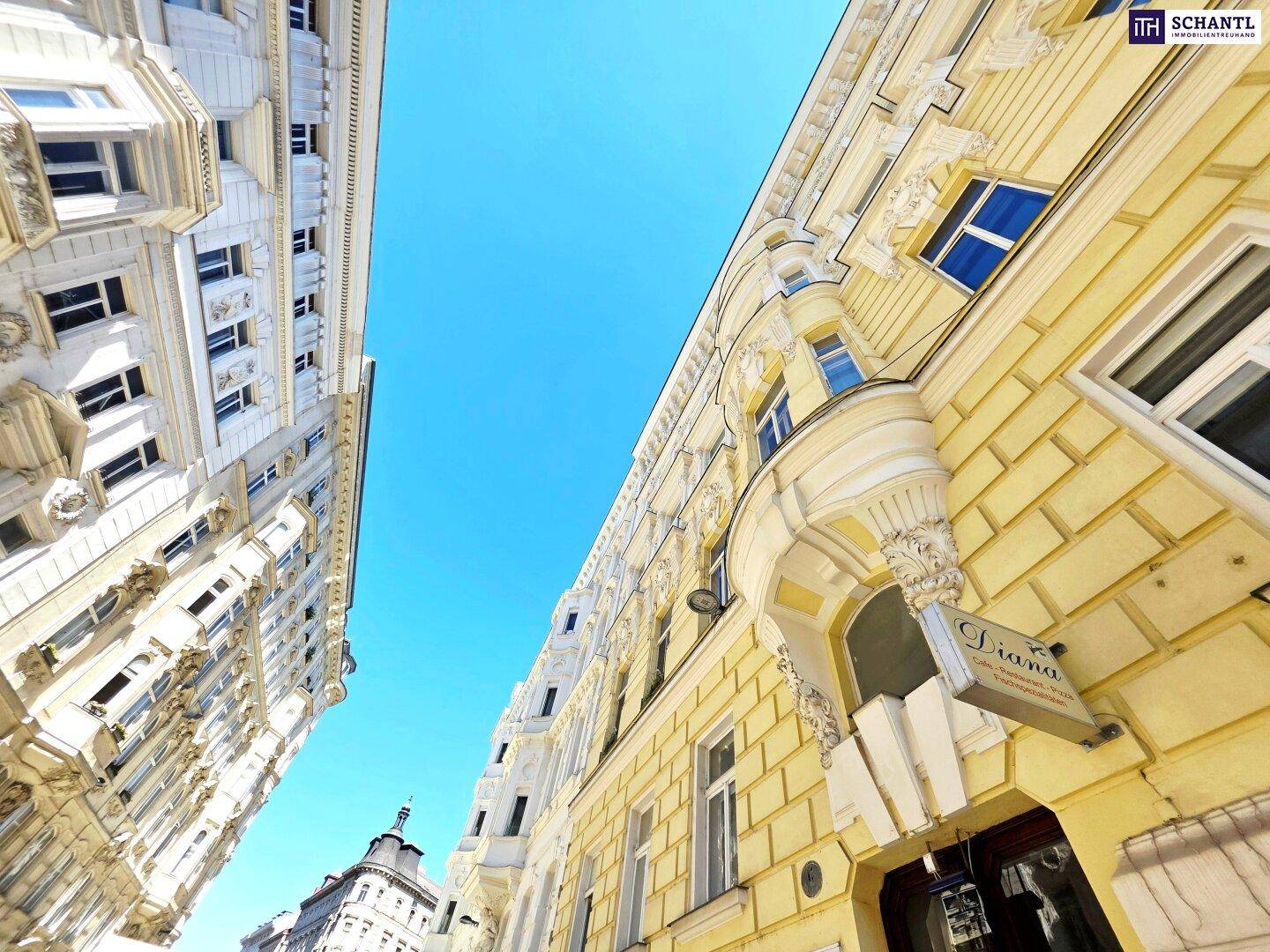 Historische Gebäude mit gelber und weißer Fassade unter strahlend blauem Himmel in der Stadt.