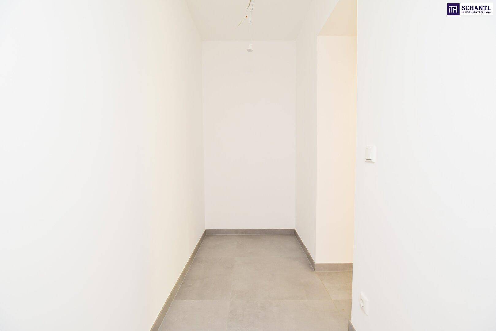 Heller, leerer Flur mit Fliesenboden, der verschiedene Räume im modernen Neubau verbindet.