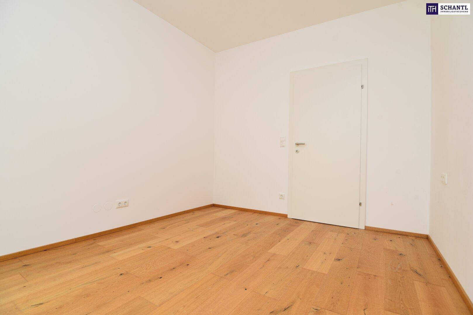 Helles Schlafzimmer mit warmem Holzboden und weiß gestrichenen Wänden, bereit zur Einrichtung.