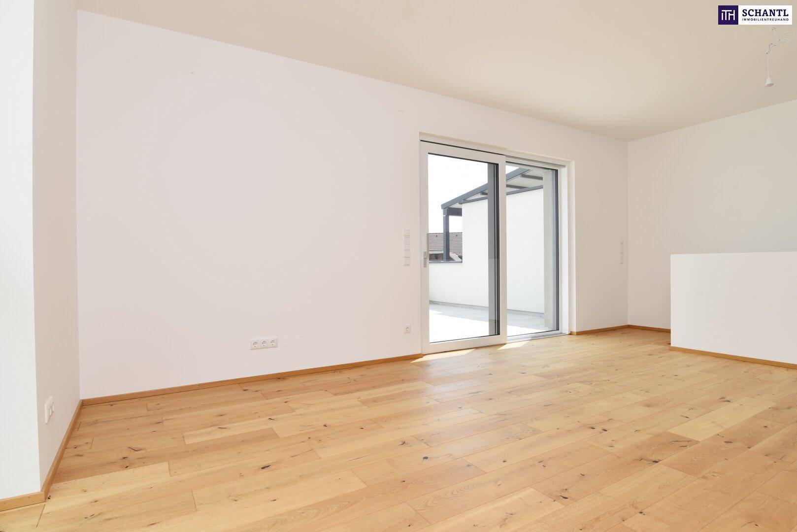 Geräumiges Zimmer mit Holzboden und großer Schiebetür zu einem sonnigen Außenbereich.