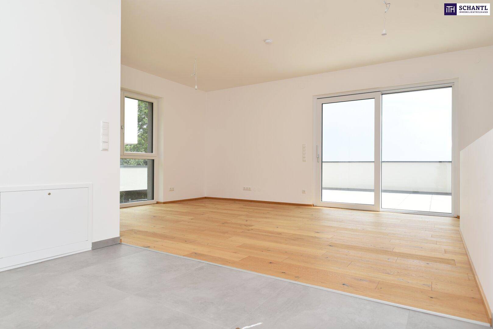 Offener Wohnbereich mit Holzboden und großen Schiebetüren, die viel Tageslicht hereinlassen.
