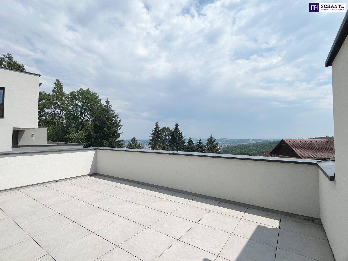 Weitläufige Dachterrasse mit hellen Fliesen und Panoramablick über die Landschaft.