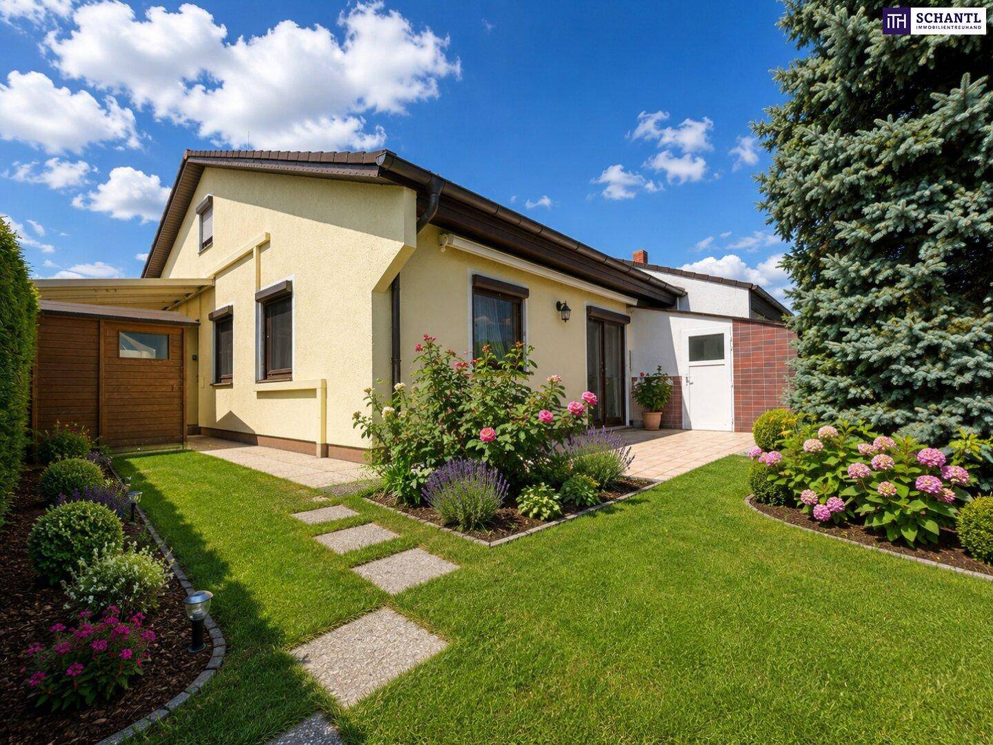 Gepflegter Gartenbereich mit blühenden Sträuchern und einem charmanten Einfamilienhaus.