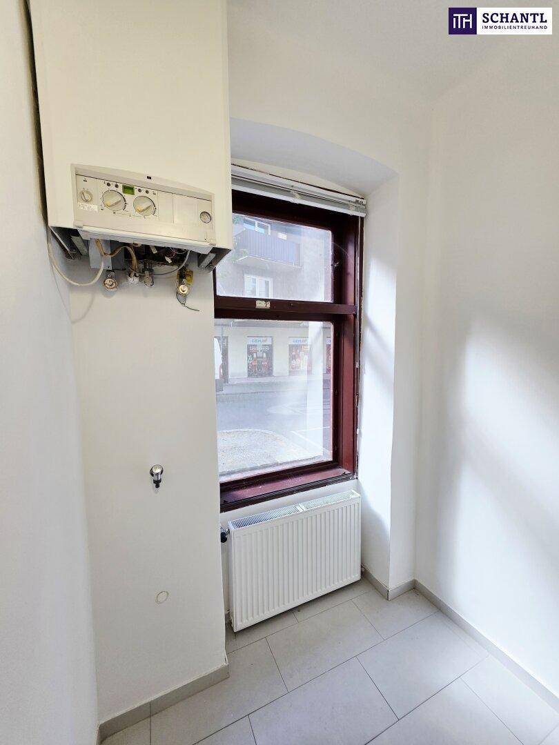 Kleiner Hauswirtschaftsraum mit Gastherme, Fenster und Heizkörper, ideal für technische Installationen.