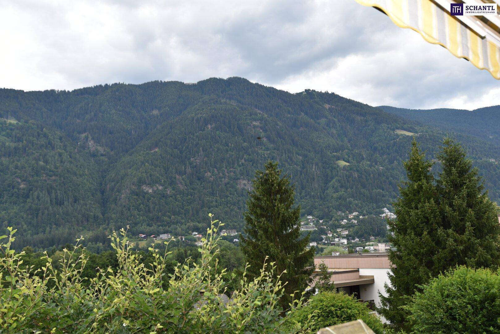 Panoramablick auf die bewaldeten Berge unter einem bewölkten Himmel, von einem Balkon aus.