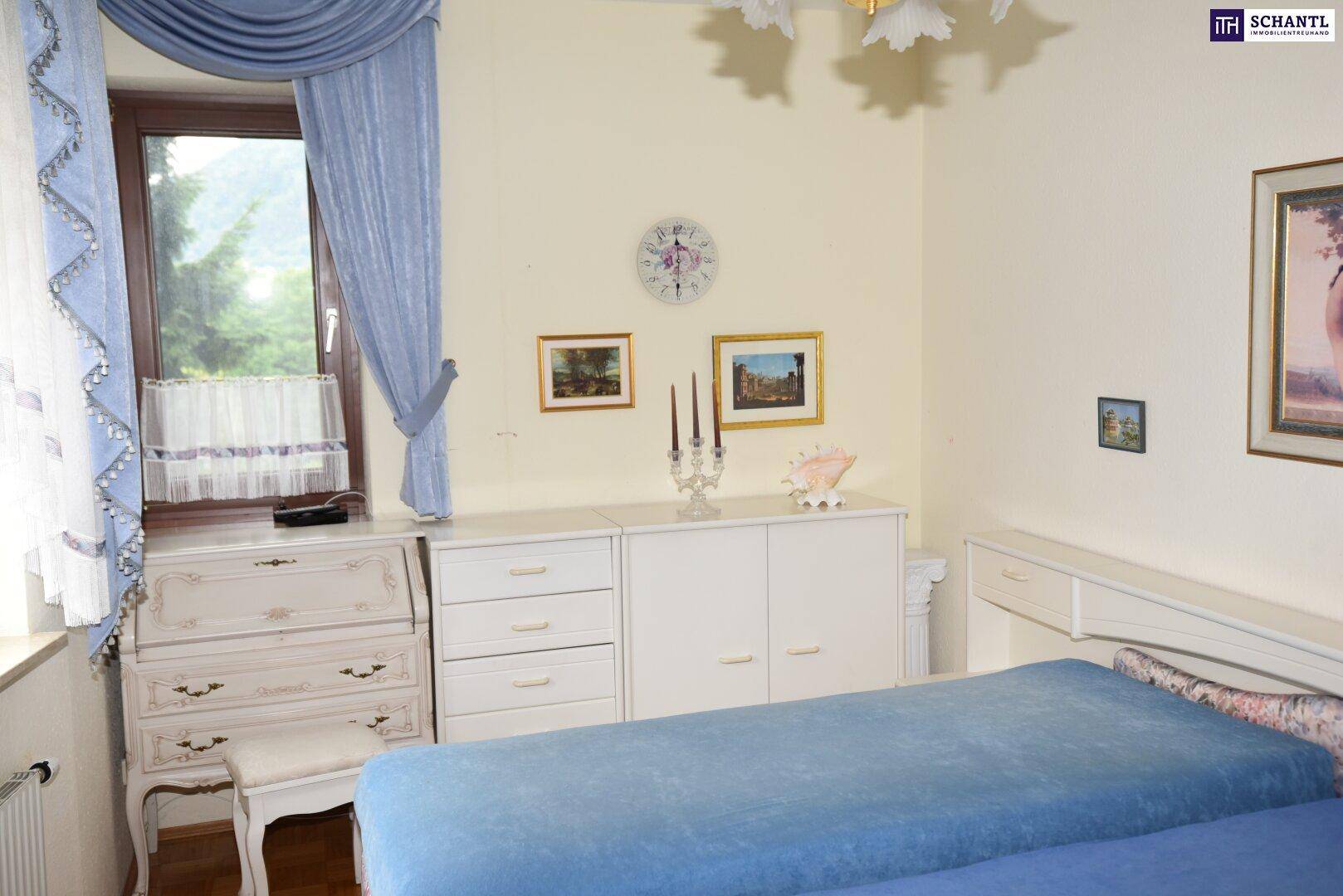 Gemütliches Schlafzimmer mit Bett, weißer Kommode und traditionellen Bildern an der Wand.