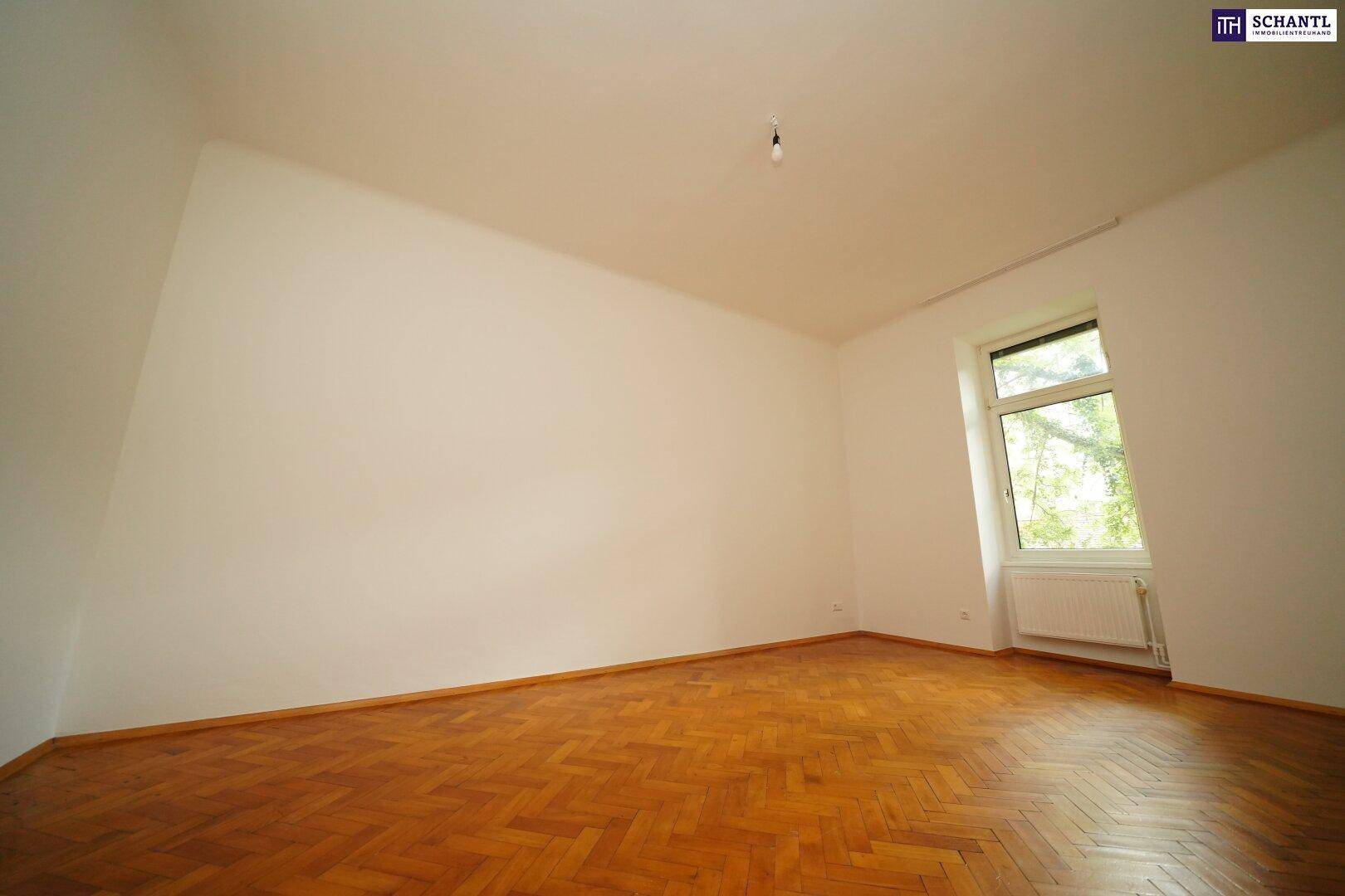Helles Schlafzimmer mit Fischgrätparkett und einem Fenster, das viel Tageslicht bietet und eine freundliche Atmosphäre schafft.