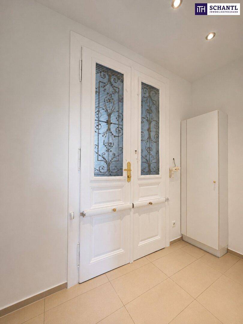 Eingangsbereich mit doppelter Flügeltür, Fliesenboden und Einbaustrahler in der Decke.