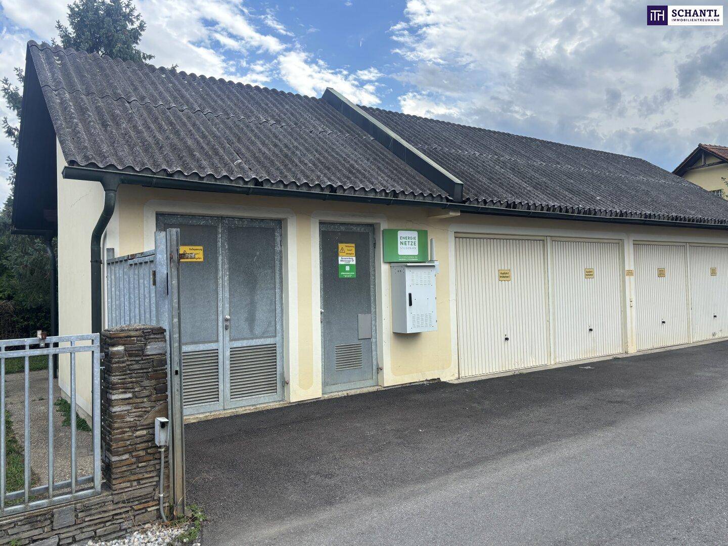 Vorderansicht des Garagengebäudes mit mehreren Toren und technischen Installationen.