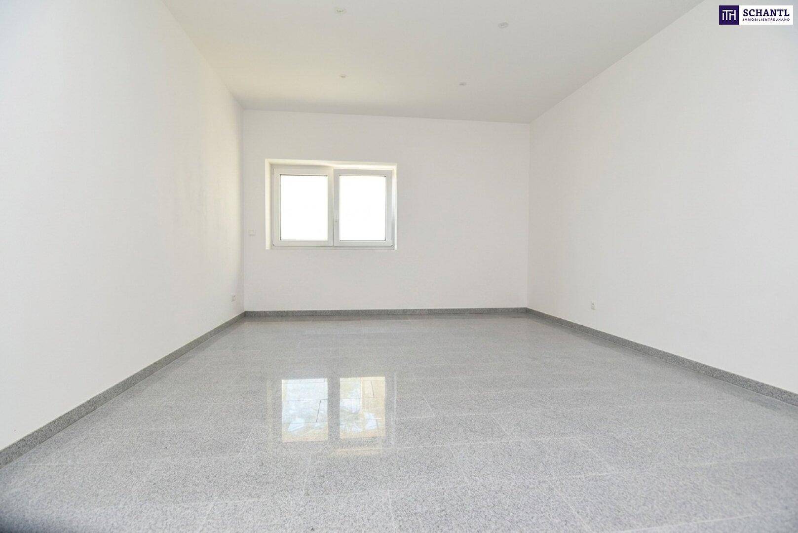 Unmöblierter Raum mit Fenster, grauen Fliesen und weißen Wänden, bietet vielseitige Nutzungsmöglichkeiten.