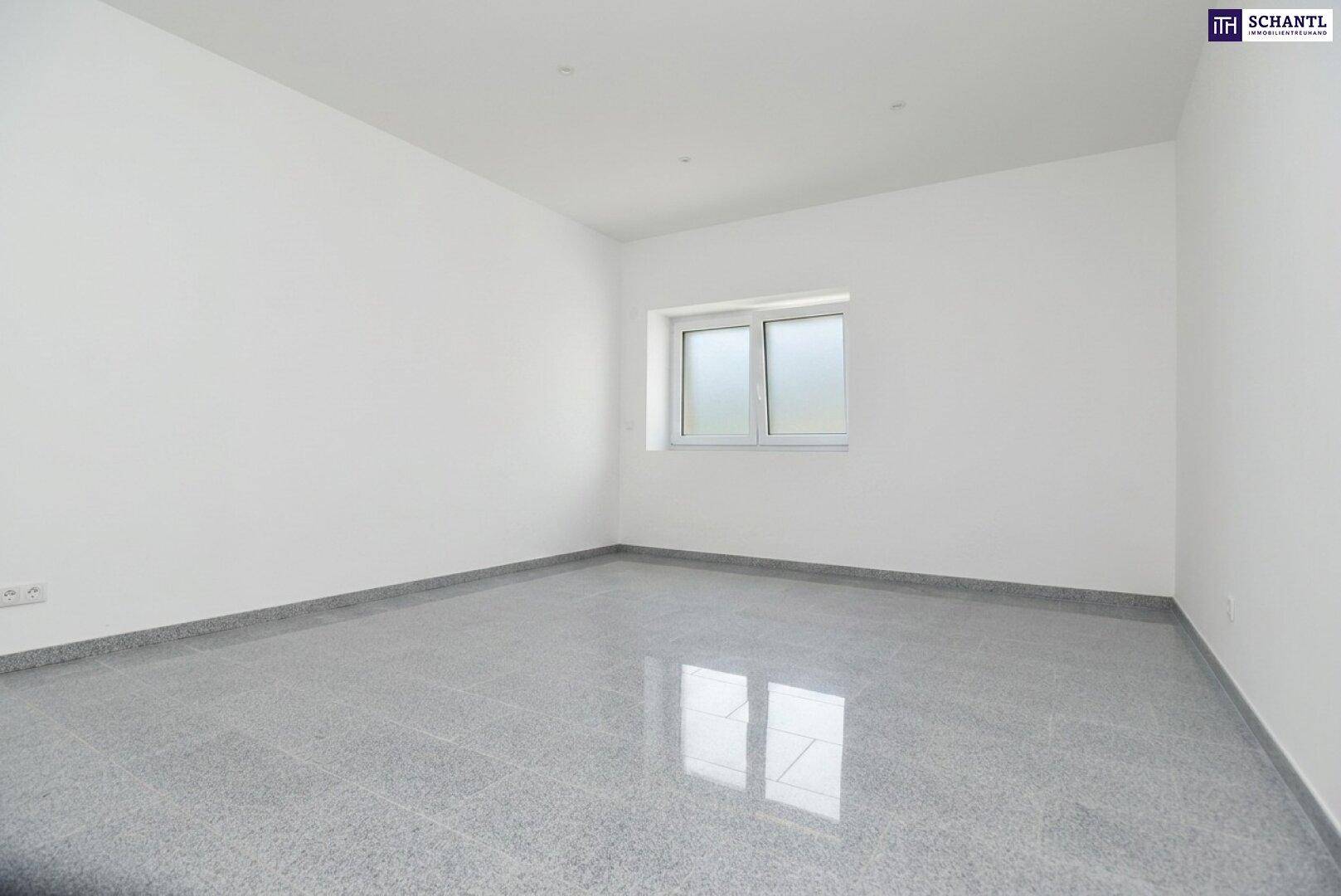 Unmöblierter Raum mit Fenster, grauen Fliesen und weißen Wänden, bietet vielseitige Nutzungsmöglichkeiten.