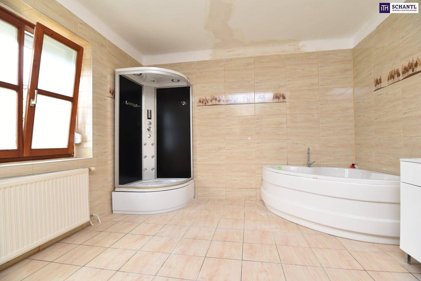 Geräumiges Badezimmer mit beigefarbenen Fliesen, Duschkabine und Badewanne, mit Fenster.