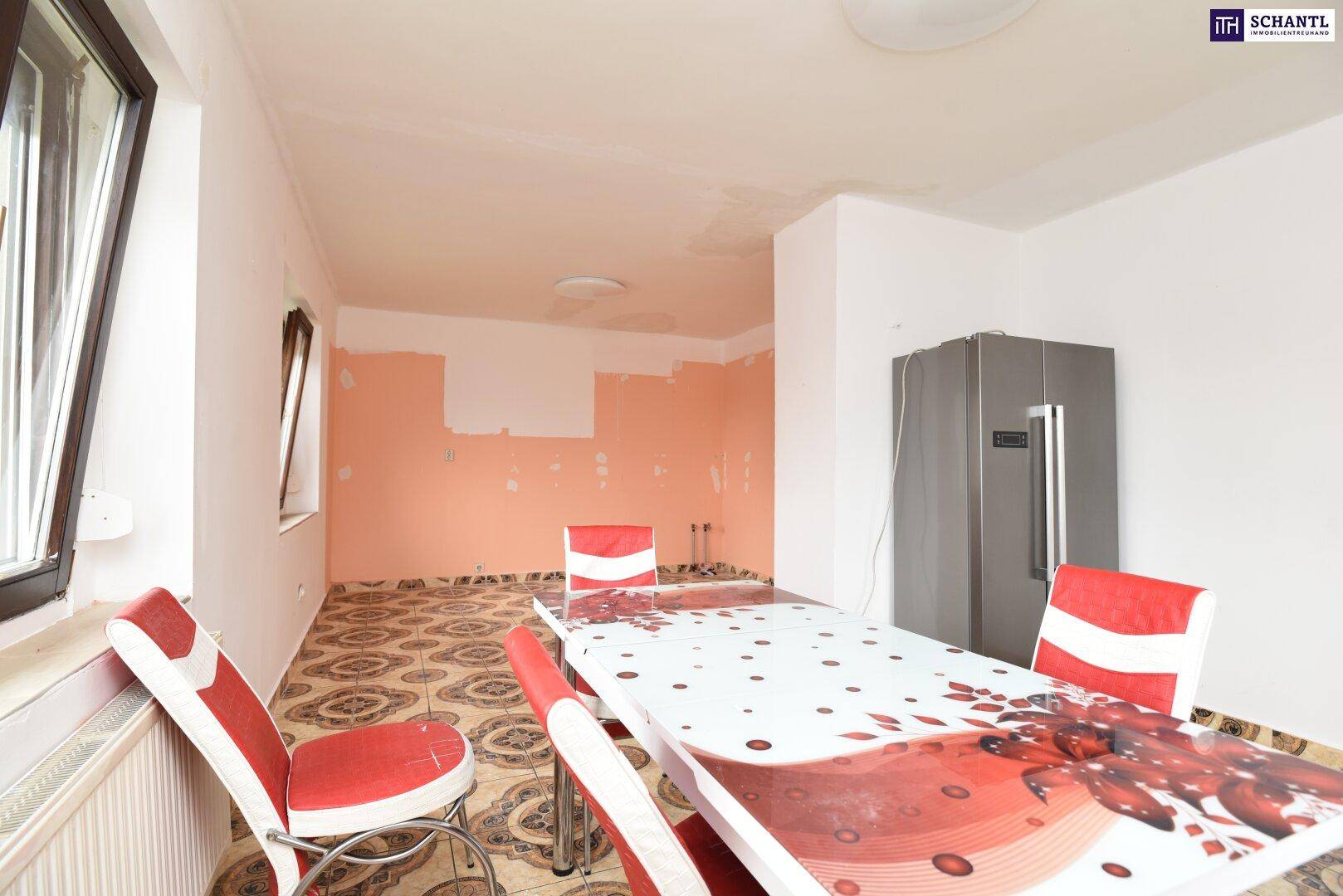 Essbereich mit gemusterten Fliesen, einem Esstisch und einem großen Kühlschrank, renovierungsbedürftig.