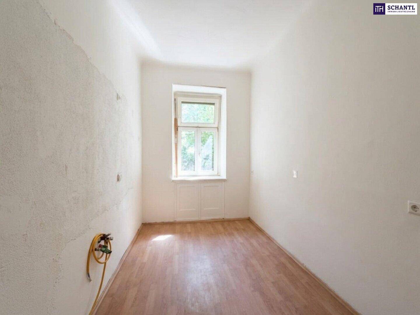 Heller Raum mit Laminatboden und Fenster, ideal für die Einrichtung einer Küche.
