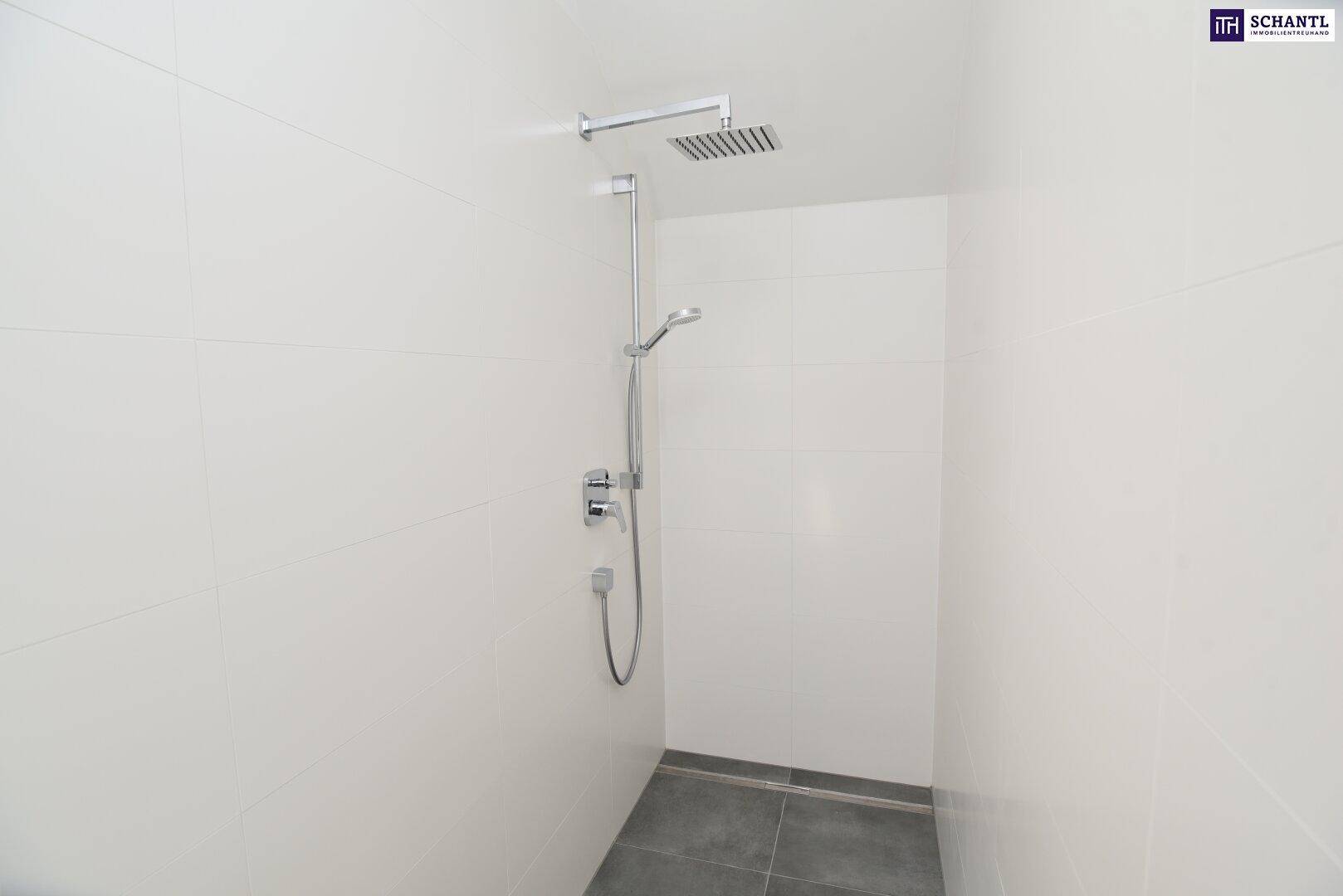 Helle Duschkabine mit modernen weißen Fliesen und einer luxuriösen Regendusche.