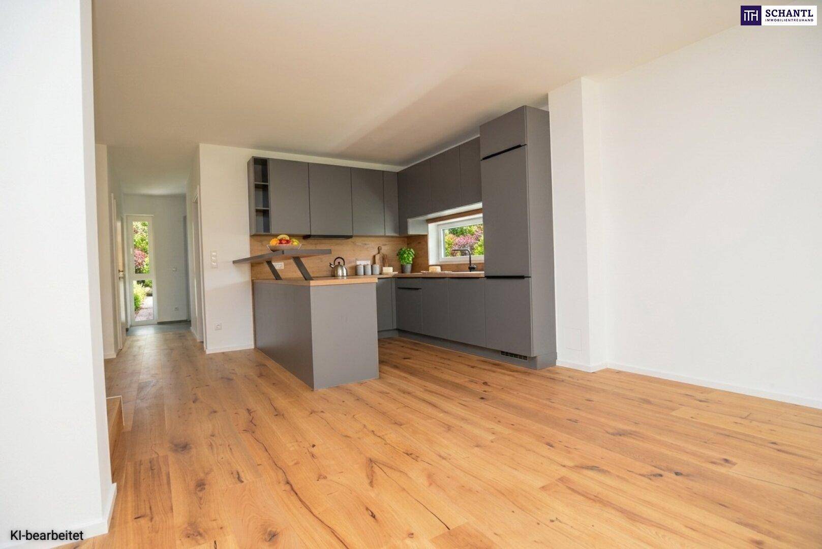 Offener Wohnbereich mit moderner Küche, Holzboden und Fenster mit Blick ins Grüne.